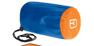 Es ist ein Biwak-Sack in den Farben blau und orange zu sehen. Auf der Innenseite ist der Sack mit einer silber reflektierenden Folie beschichtet.