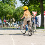 Ein Mädchen von hinten auf einem Fahrrad fährt einen Radparcours.