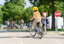 Ein Mädchen von hinten auf einem Fahrrad fährt einen Radparcours.